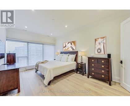 A bedroom with a bed, nightstand, and dresser.