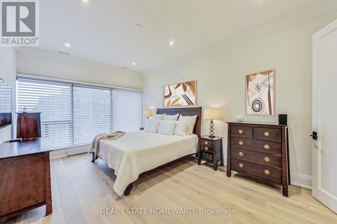 A bedroom with a bed, nightstand, and dresser.