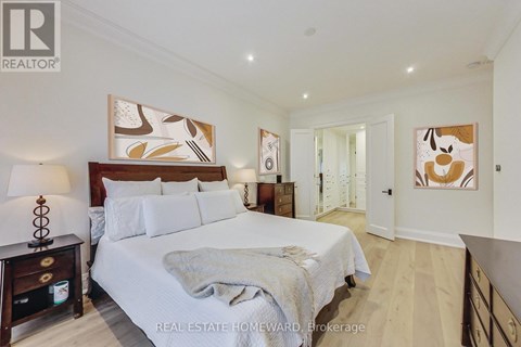 A bedroom with a large bed and a painting on the wall.
