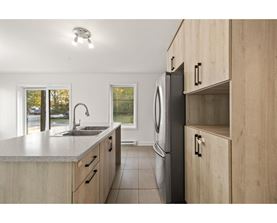 A modern kitchen with wooden cabinets and a stainless steel dishwasher.