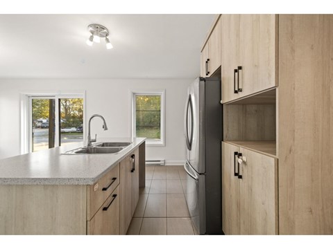 A modern kitchen with wooden cabinets and a stainless steel dishwasher.