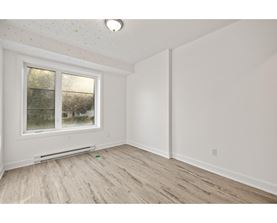 A room with a window and a radiator on the floor.