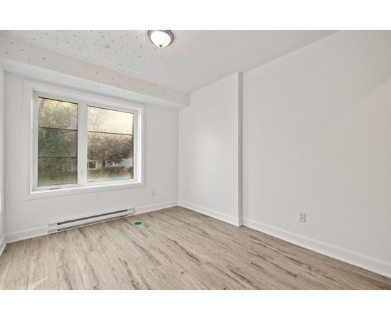 A room with a window and a radiator on the floor.
