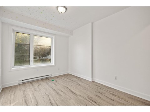 A room with a window and a radiator on the floor.