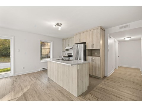A kitchen with wooden cabinets and a refrigerator.