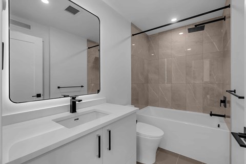 A white bathroom with a sink, toilet, and bathtub.