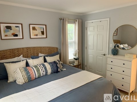 A bedroom with a bed, dresser, and two pictures on the wall.