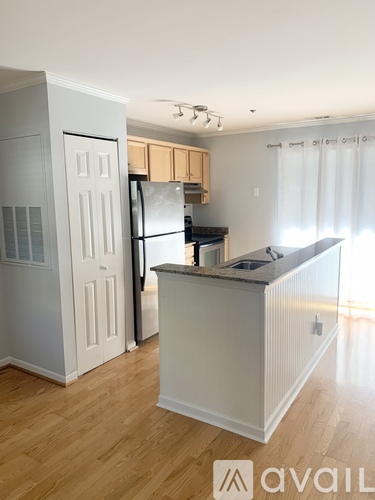 A kitchen with a white refrigerator and wooden cabinets.