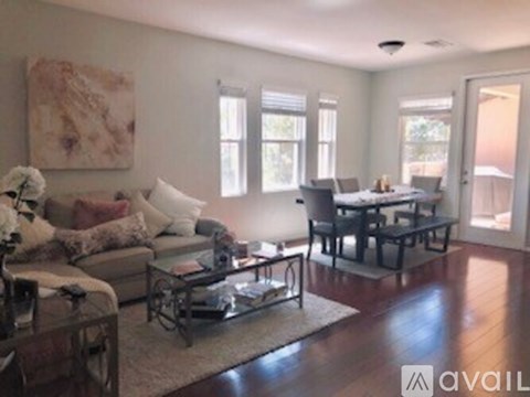 A living room with a couch, coffee table, and a painting on the wall.