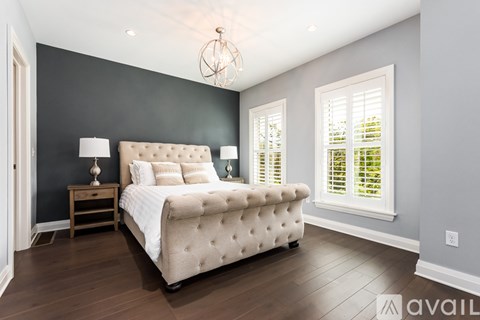 A bedroom with a large bed and a chandelier.