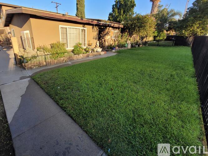 A house with a brown exterior and a green lawn.