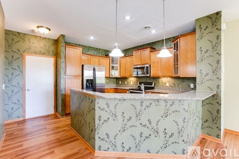 A kitchen with wooden cabinets and a patterned backsplash.