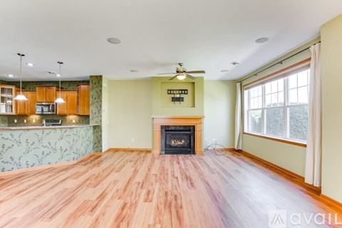 A living room with a fireplace and wooden floors.