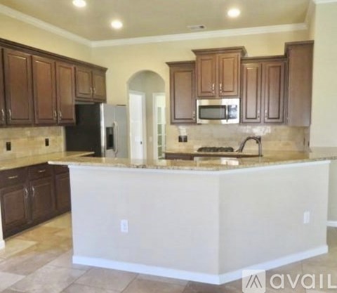 A kitchen with brown cabinets and a white island.