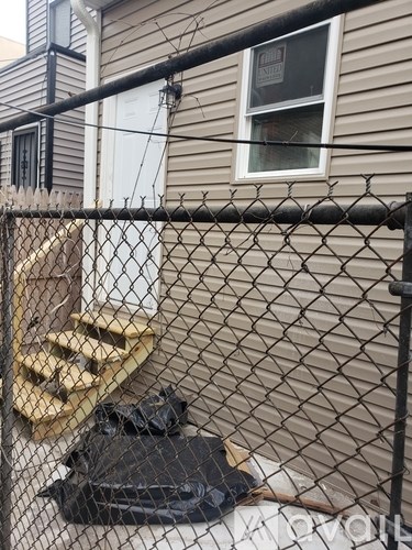 A black fence with a white door and a window.