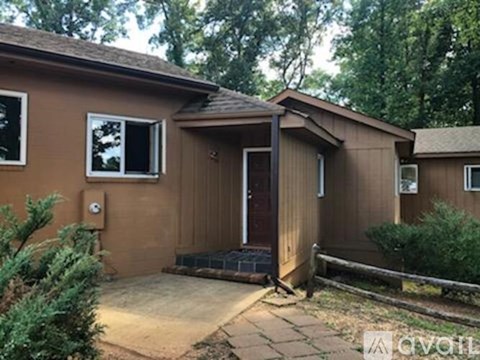 A small brown house with a porch and a door.