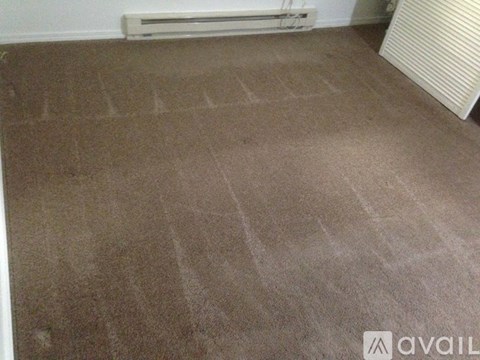 A room with a carpeted floor and a wall-mounted air conditioner.
