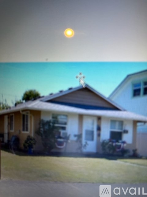 A house with a cross on the roof and a sun in the sky.