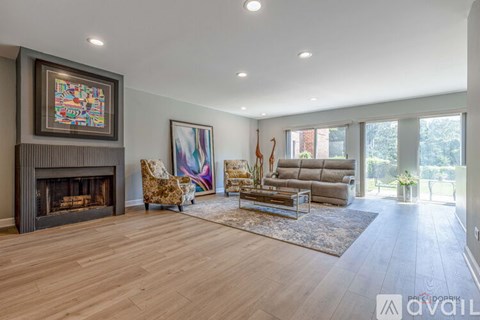 A living room with a fireplace and a painting on the wall.