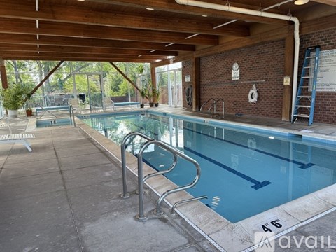 A large indoor swimming pool with a ladder on the side.