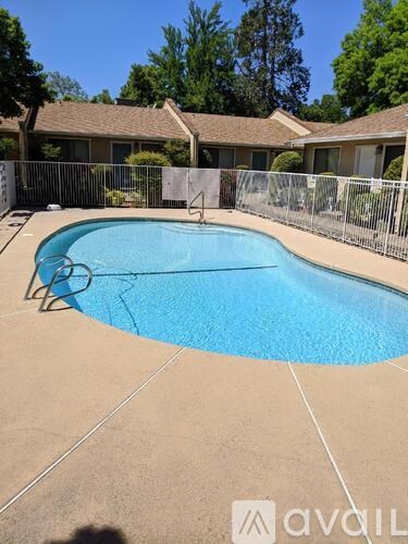 A swimming pool surrounded by a fence and trees.