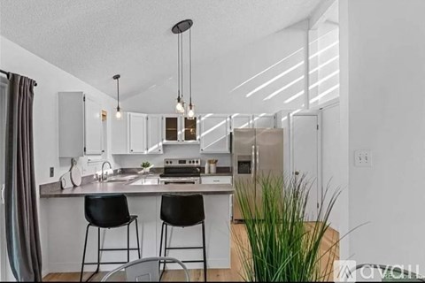 A modern kitchen with white cabinets and a center island.