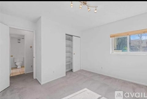 A room with a toilet, a sink, and a window.