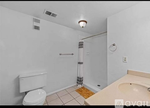 A white toilet is next to a sink in a small bathroom.