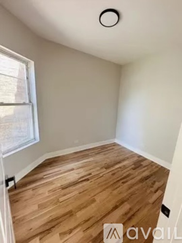 A room with wooden flooring and a window.