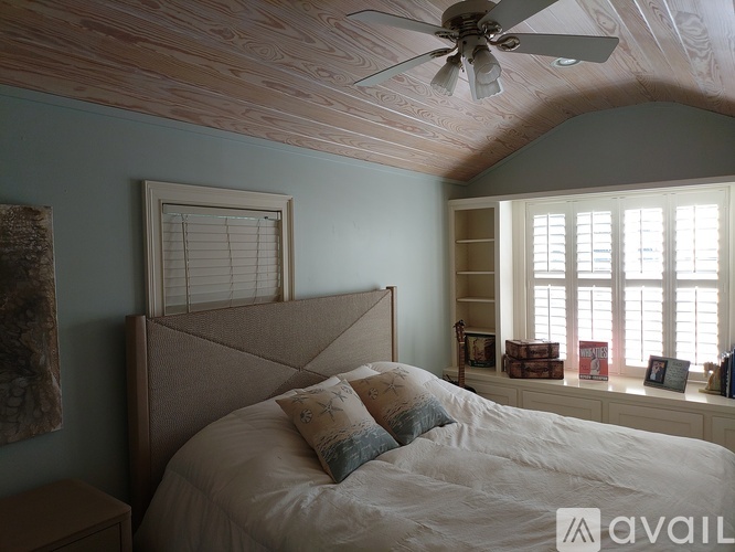 A bedroom with a large bed and a ceiling fan.
