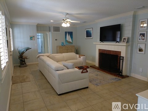 A living room with a white couch and a fireplace.
