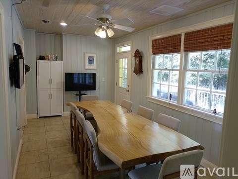 A dining room with a wooden table and chairs.
