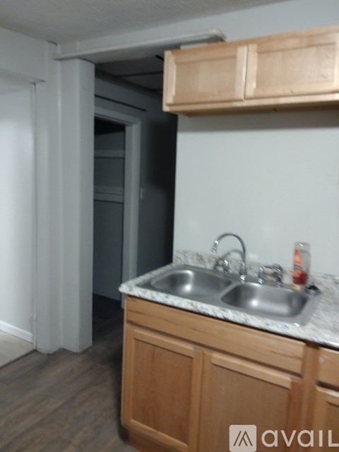 A kitchen with a sink and wooden cabinets.