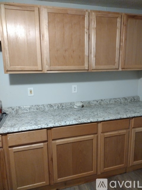A kitchen with wooden cabinets and granite countertops.