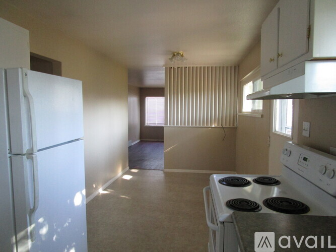 A kitchen with a white fridge and stove.