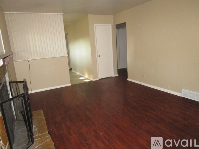 A room with wooden flooring and a white door.