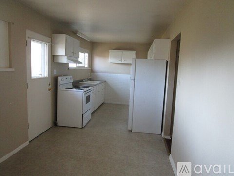A small kitchen with white appliances and cabinets.