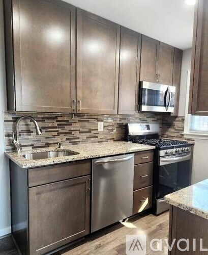 A kitchen with brown cabinets and granite countertops.
