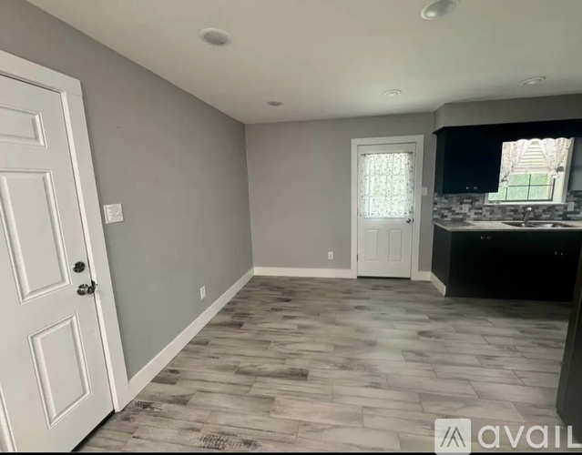 A room with a wooden floor and a white door.