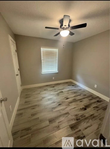 A room with wooden flooring and a ceiling fan.