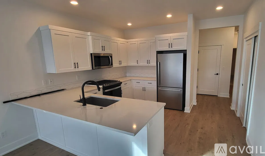 A kitchen with white cabinets and a black countertop.