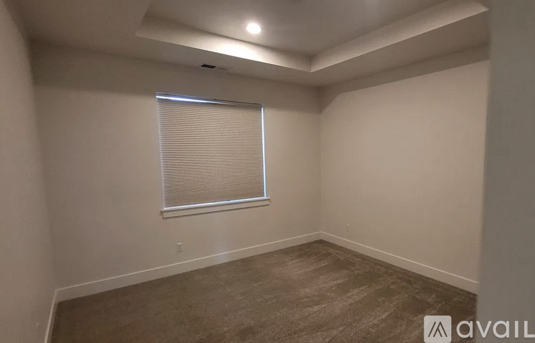 A room with a window covered by blinds and a carpeted floor.