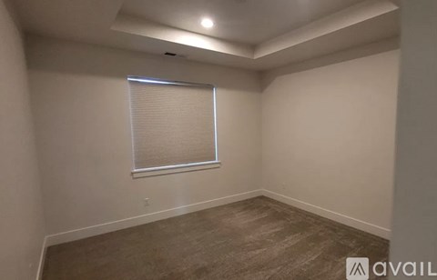 A room with a window covered by blinds and a carpeted floor.