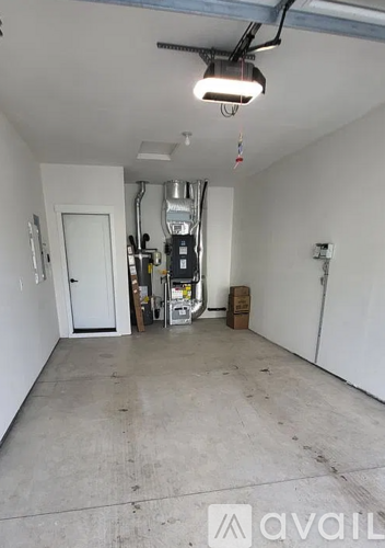 A large empty room with a white door and a white wall.