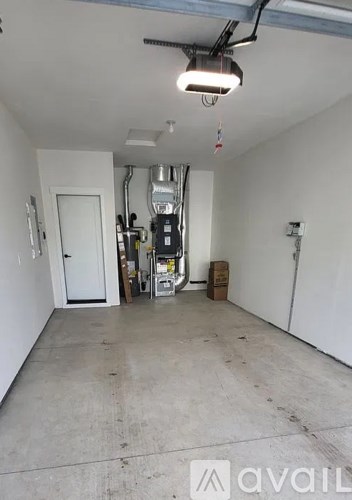 A large empty room with a white door and a white wall.