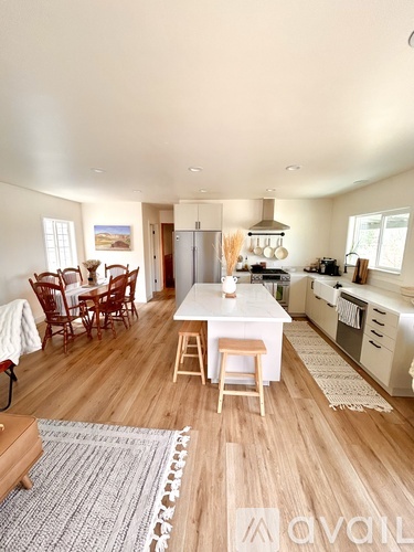A kitchen with a dining table and chairs.