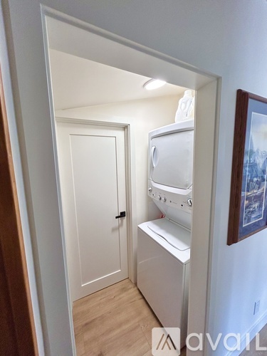 A white washing machine is in a small room.