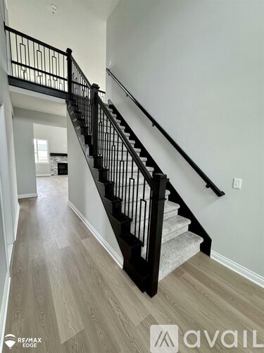 A staircase with a black railing and wooden steps.