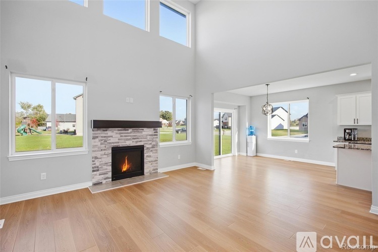 A spacious living room with a fireplace and large windows.