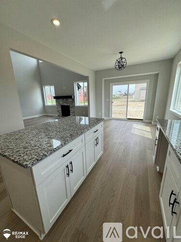 A kitchen with granite countertops and white cabinets.